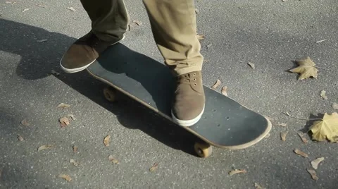 Autumn, fallen leaves on the road, the guy on a skateboard, moving, close-up. Stock Footage 63210111