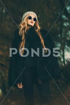 Autumn fashion shot. Trendy young woman in warm clothes posing in the autumn Stock Photos