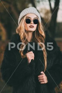 Autumn fashion shot. Trendy young woman in warm clothes posing in the autumn Stock Photos