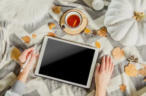 Autumn flat lay top view home workspace with feminine hands hold tablet and cup Stock Photos