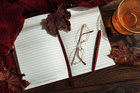 Autumn flat lay with warm tea, open notebook, and fall decorations Fotos de archivo