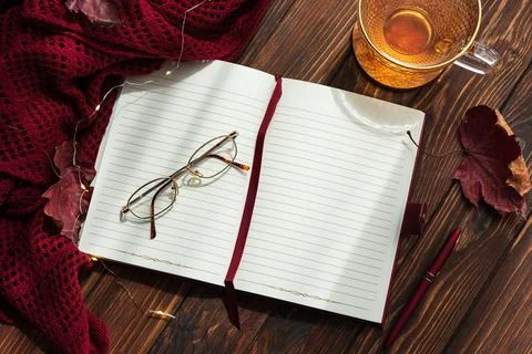 Autumn flat lay with warm tea, open notebook, and fall decorations Stock Photos