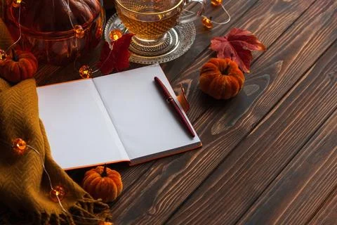 Autumn flat lay with warm tea, notebook, and fall decorations Stock Photos