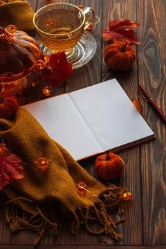 Autumn flat lay with warm tea, notebook, and fall decorations Stock Photos