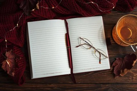 Autumn flat lay with warm tea, open notebook, and fall decorations Stock Photos