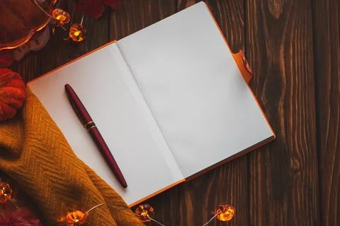 Autumn flat lay with warm tea, notebook, and fall decorations Stock Photos