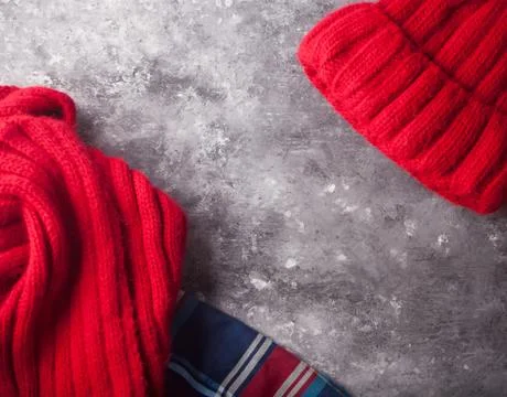 Autumn flatlay composition. Frame of red scarf, skirt, cap on concrete backgr Stock Photos