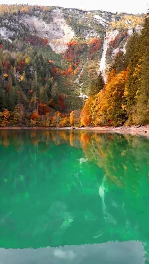 Autumn Forest Reflection in Emerald Alpine Lake with Waterfall Stock Footage 337322905