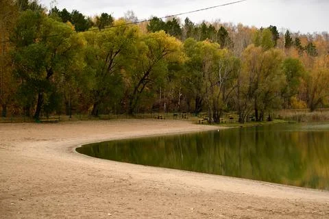 Autumn forest on a small island. Reflection of orange and green trees in th.. Stock Photos