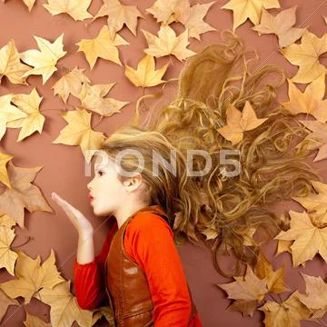 Autumn girl on dried leaves blowing wind lips Stock Photos