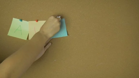 Autumn. Hands pining and taking off sticky windy notes on pin board funny Stock Footage 99566630