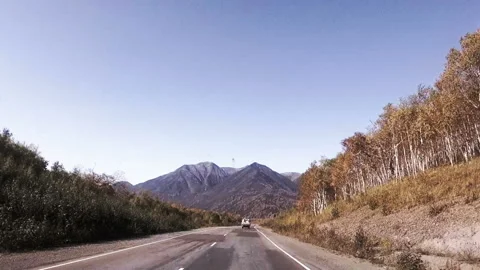 Autumn in Kamchatka. the car is driving on a flat road leading to the mountains Video stock 96592453
