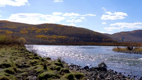 Autumn Landscape Featuring A Flowing River And Golden Forested Mountains Stock Footage 342325947