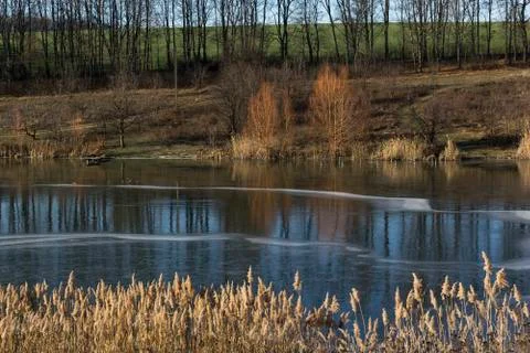 Autumn landscape, on the river a thin pattern of ice, blue sky, sunny day Stock Photos
