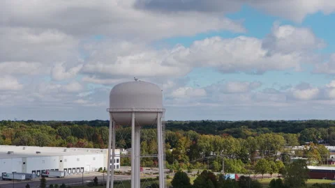 Autumn logistics unfold as Amazon trucks move beneath Southaven water tower Stock Footage 328337813