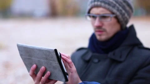 In Autumn, a Man Uses Tablet Stock Footage 56639776