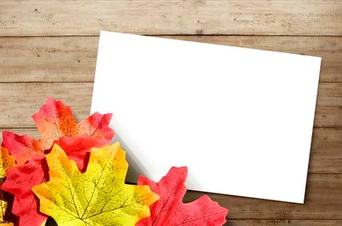 Autumn maple leaf and empty white paper with wooden table background 写真素材