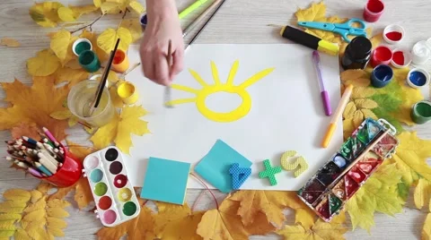 Autumn maple leaves on the table and brush drawing sun Stock Footage 67941478