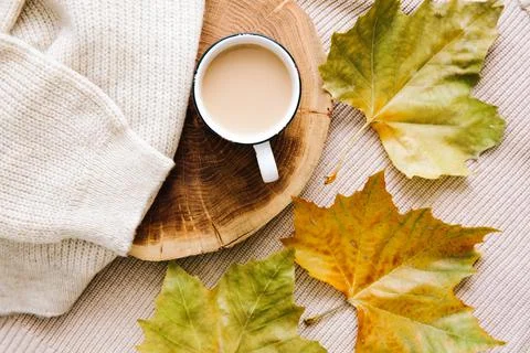 Autumn mood: cup of coffee, warm wool sweater and yellow leaves.  Stock Photos