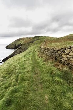 Autumn or fall path with  dry stone wall, and sea. Stock Photos