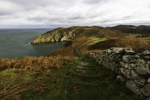 Autumn or fall path with remains of dry stone wall, and sea. Stock Photos