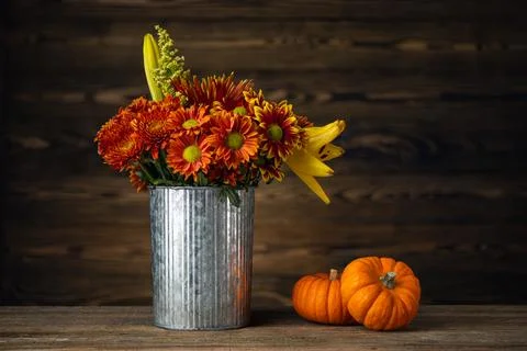 Autumn or Fall still life. Pumpkin and bouquet of flowers Stock Photos
