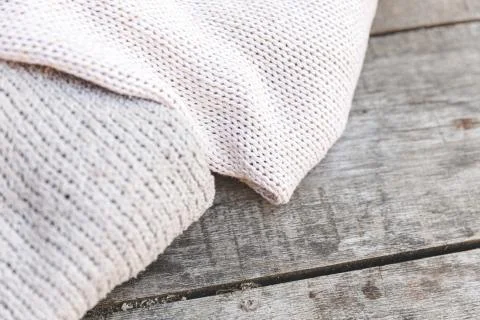 Autumn or winter background. Stack of cozy knitted wool clothes sweaters on w Stock Photos