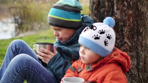 In the autumn Park children sitting on the lawn and drink hot tea, walk in the Stock Footage