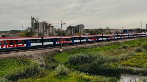 Autumn. A passenger train is passing by. There is a concrete plant at the back. Stock Footage 161119143