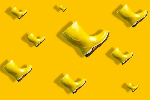 Autumn pattern of flying yellow rubber boots with shadow Stockfoto's