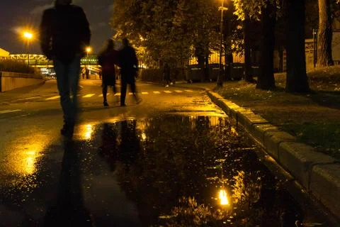 Autumn. A puddle on the pavement with a reflection of lanterns in the evening Фото