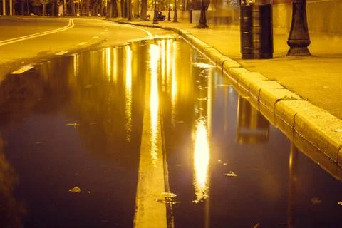 Autumn. A puddle on the pavement with a reflection of lanterns in the evening 스톡 사진