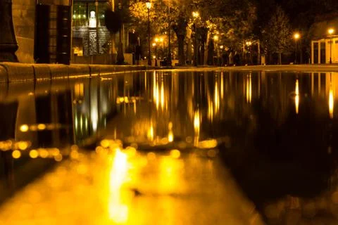 Autumn. A puddle on the pavement with a reflection of lanterns in the evening 스톡 사진