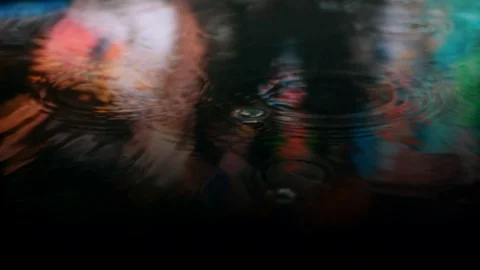 Autumn rain drops falling into puddle on asphalt at night. Big city reflection Stock Footage 127226538