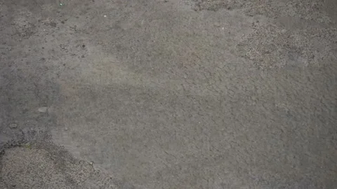 Autumn raindrops fall into a large puddle on asphalt, flooding street. Stock Footage 138267848