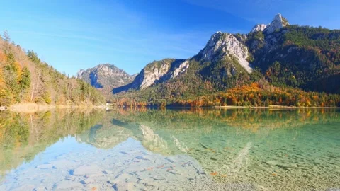 Autumn reflections in a tranquil mountain lake near Tegelberg in Bavaria with Stock Footage 309093241