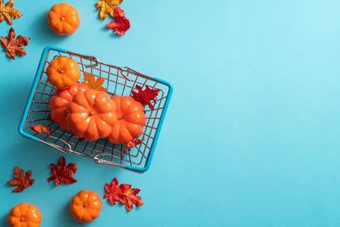 Autumn shopping design concept background with shopping cart, maple leaves an Stock Photos