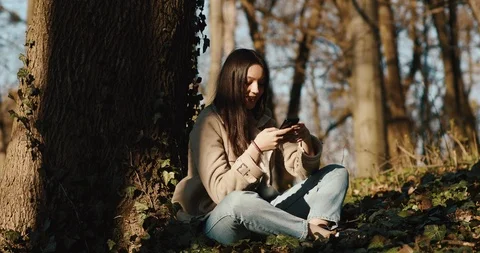 Autumn / spring vibes. Wind blows woman's hair while she reads something in her Stock Footage 106443494