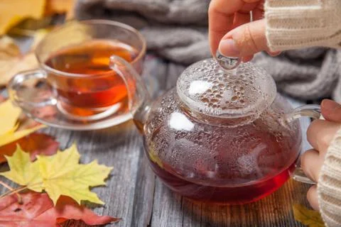 Autumn Still Life: Tea on maple leaves on a wooden table Stock Photos