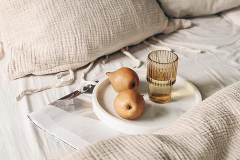 Autumn, summer breakfast in bed composition. Glass of water, folded newspapers 写真素材