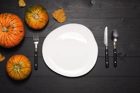 Autumn table setting with empty white plate and pumpkins. Halloween or thanks Stock Photos