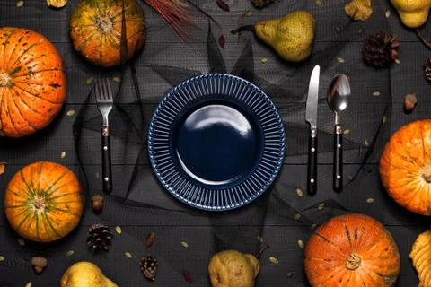 Autumn table setting with empty white plate and pumpkins. Stock Photos