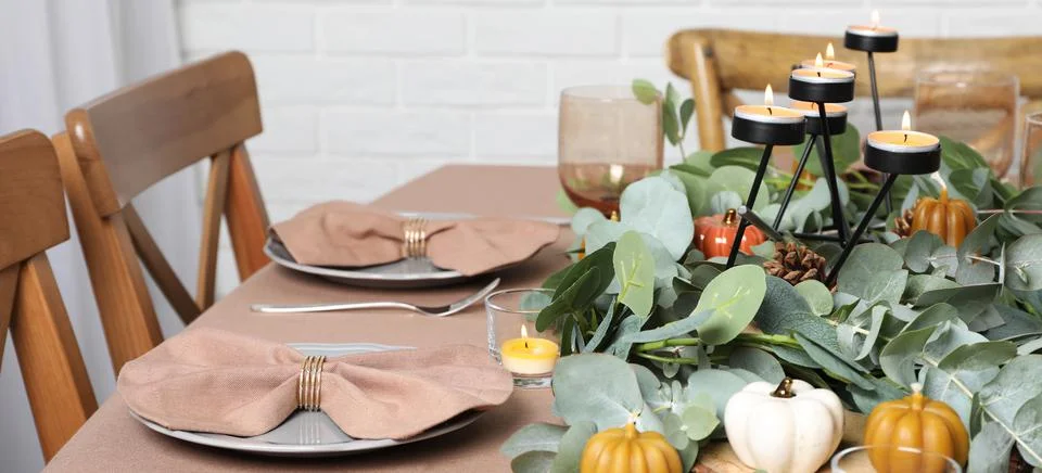 Autumn table setting with eucalyptus branches and pumpkins indoors. Banner de Stock Photos