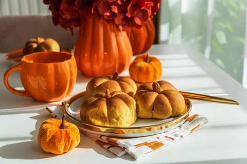 Autumn Table Setting with Pumpkin Shaped Buns with Cinnamon and Cup of Tea Stock Photos