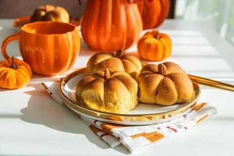 Autumn Table Setting with Pumpkin Shaped Buns with Cinnamon and Cup of Tea Stock Photos