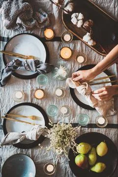 Autumn table setting with tableware, decor and female hands Stock Photos