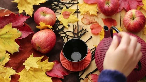 Autumn tea drinking. Maple leaves, apples,tea  ,  warm blanket on a wooden table Stock Footage 73968316