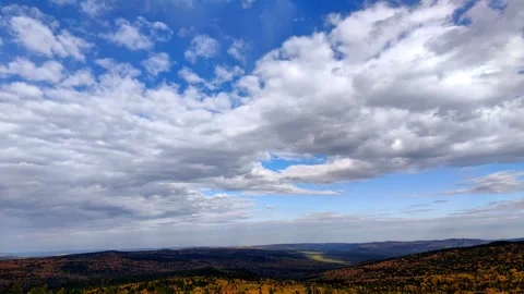Autumn timelapse blue sky with clouds over hilly forest valley movement sunlight Stock Footage 302940343