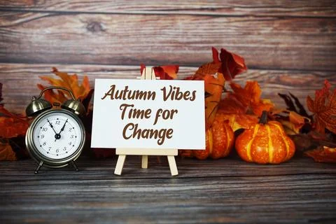 Autumn Vibes Time For Change text with alarm clock, maple leaf and pumpkins.. Stock Photos