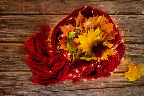 Autumn warm composition in red tones on a wooden background with a cup of tea Stock Photos